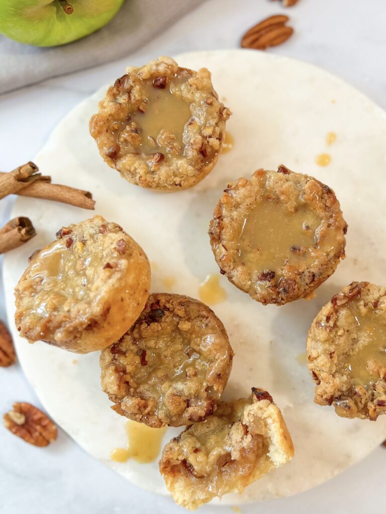 a collection of mini apple pie drizzled with caramel sauce.