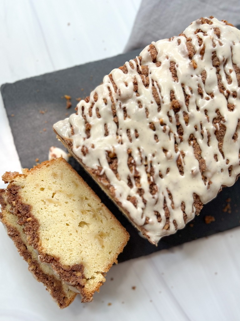 A loaf of gluten-free Dutch apple bread with a slice removed, showcasing its delicious swirls and texture.